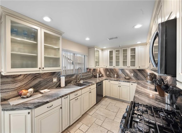 kitchen featuring black appliances, a sink, backsplash, stone tile flooring, and recessed lighting