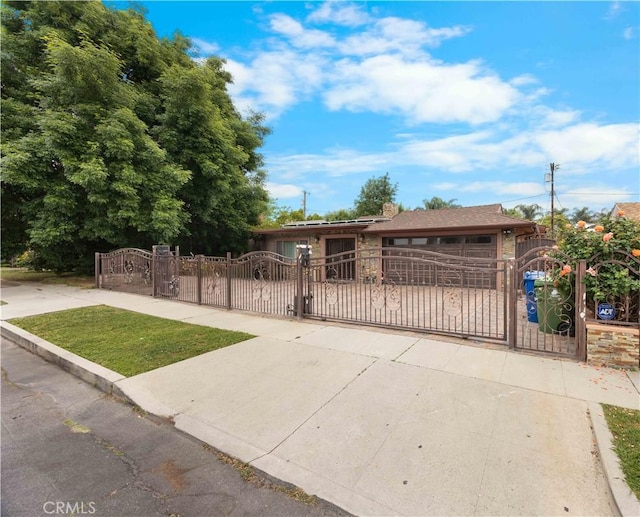 ranch-style home featuring a gate and a fenced front yard