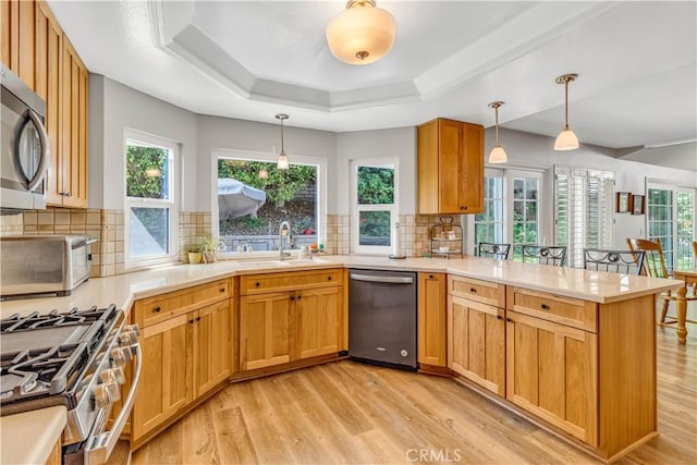 25572 Saltwater Dr, Dana Point, CA 92629 - kitchen with stainless steel appliances, light wood-style floors, a peninsula, light countertops, and decorative backsplash