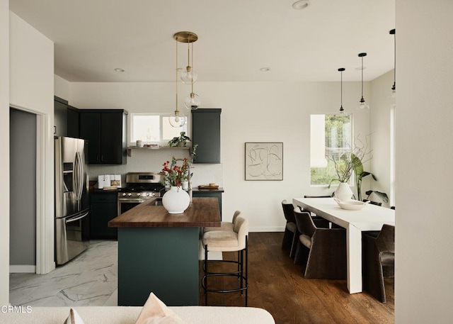 3826 Clayton Ave, Los Angeles, CA 90027 - kitchen with butcher block countertops, stainless steel appliances, dark cabinetry, decorative light fixtures, and recessed lighting