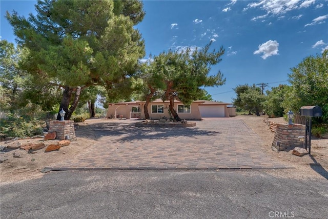 54955 Benecia Trl, Yucca Valley, CA 92284 - view of front of home featuring a garage, driveway, and stucco siding