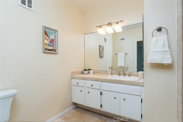 bathroom with vanity, toilet, and baseboards