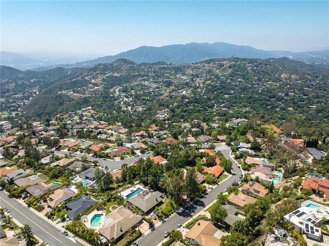aerial view of property's location featuring a mountainous background and nearby suburban area