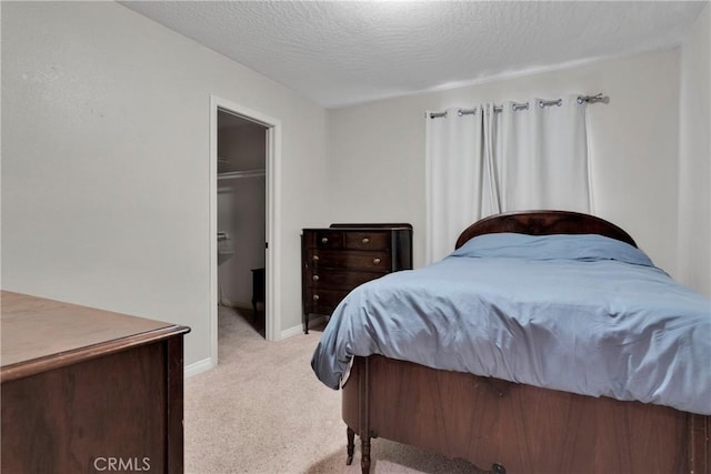 13935 Rincon Rd, Apple Valley, CA 92307 - bedroom with light carpet, a textured ceiling, a spacious closet, baseboards, and a closet