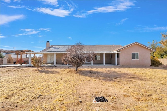 13935 Rincon Rd, Apple Valley, CA 92307 - single story home with a pergola, roof mounted solar panels, a chimney, and a patio