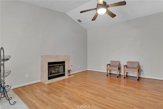 13935 Rincon Rd, Apple Valley, CA 92307 - sitting room featuring ceiling fan, light wood-style flooring, a tiled fireplace, high vaulted ceiling, and baseboards