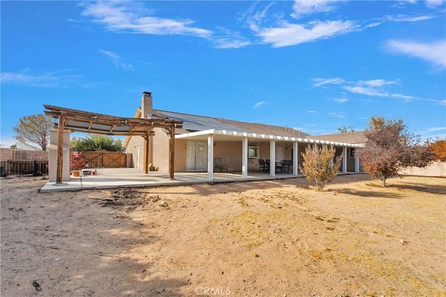 13935 Rincon Rd, Apple Valley, CA 92307 - rear view of house with a patio, fence, a pergola, and a chimney
