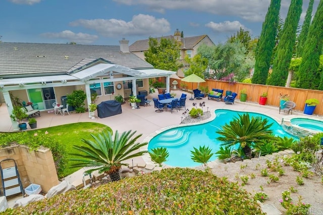 view of swimming pool featuring fence, a patio area, and a pool with connected hot tub