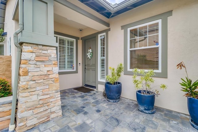 property entrance featuring stucco siding and a surveillance system