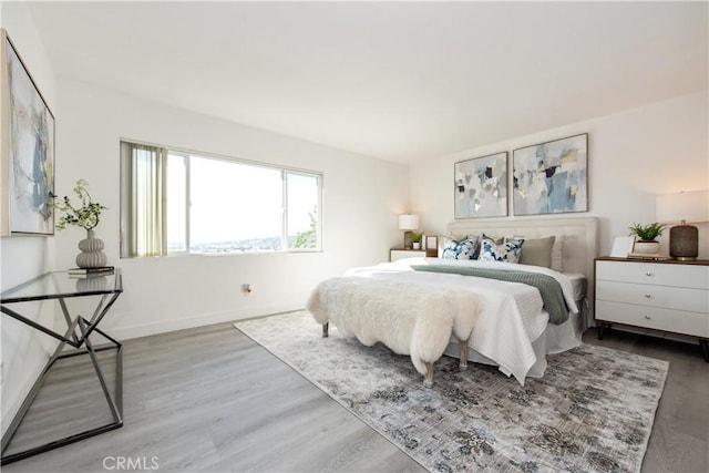 bedroom with wood finished floors and baseboards