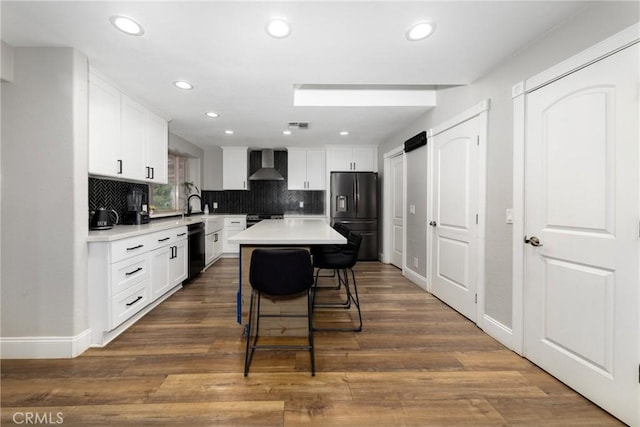 35602 Carter St, Yucaipa, CA 92399 - kitchen featuring black appliances, wall chimney range hood, light countertops, a breakfast bar area, and backsplash