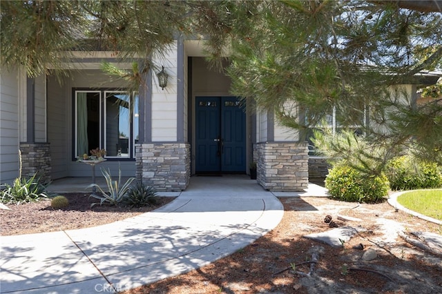 property entrance with stone siding and covered porch