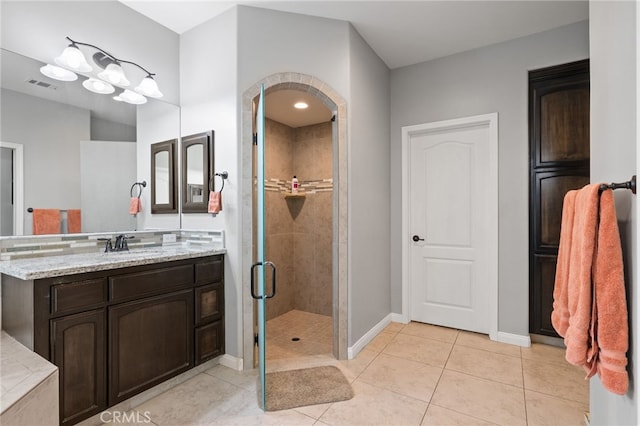 full bath featuring a shower stall, baseboards, tile patterned floors, and vanity
