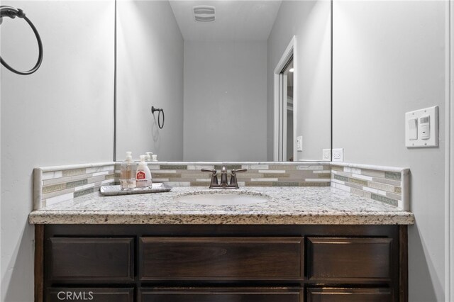 bathroom featuring decorative backsplash and vanity
