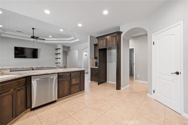 kitchen featuring stainless steel dishwasher, arched walkways, ceiling fan, dark brown cabinetry, and light tile patterned flooring