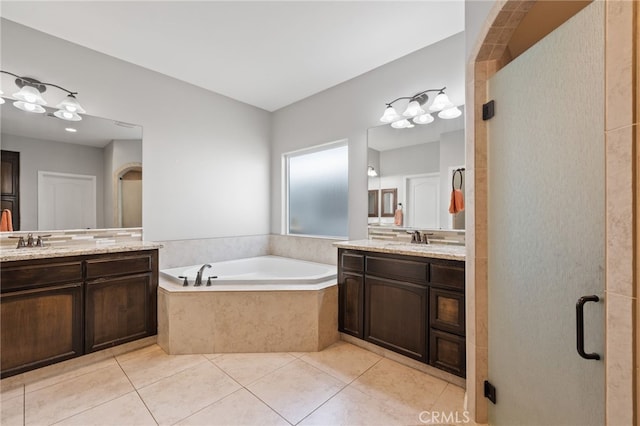 bathroom with a bath, tile patterned flooring, and two vanities