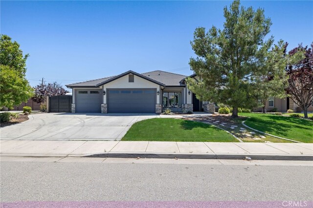 ranch-style home featuring stone siding, an attached garage, a front lawn, and driveway