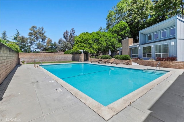 view of swimming pool with a fenced backyard and a patio