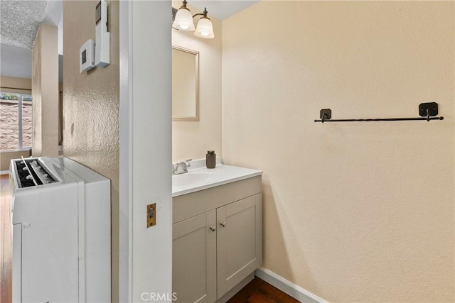 bathroom featuring vanity, baseboards, and wood finished floors