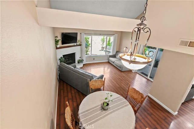 living room with wood finished floors, baseboards, and a brick fireplace