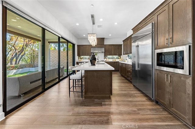 27 Alessio, Lake Forest, CA 92630 - kitchen featuring built in appliances, light countertops, wood finished floors, dark brown cabinets, and recessed lighting