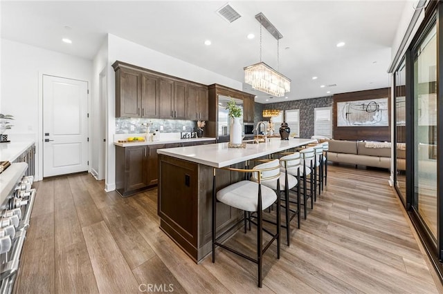 27 Alessio, Lake Forest, CA 92630 - kitchen featuring range, dark brown cabinetry, a chandelier, light wood-style floors, and recessed lighting
