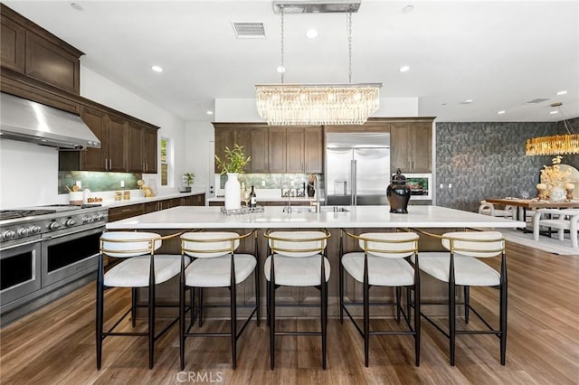 27 Alessio, Lake Forest, CA 92630 - kitchen with high end appliances, a chandelier, a sink, range hood, and a center island with sink