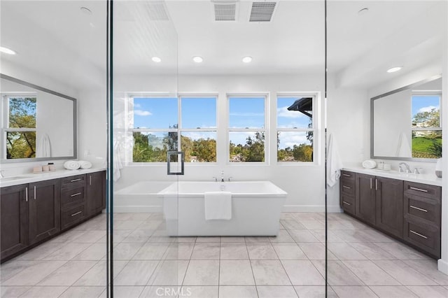 27 Alessio, Lake Forest, CA 92630 - bathroom with a freestanding tub, two vanities, tile patterned flooring, and recessed lighting