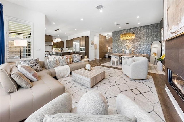27 Alessio, Lake Forest, CA 92630 - living room with light wood-style floors, a chandelier, a glass covered fireplace, and recessed lighting