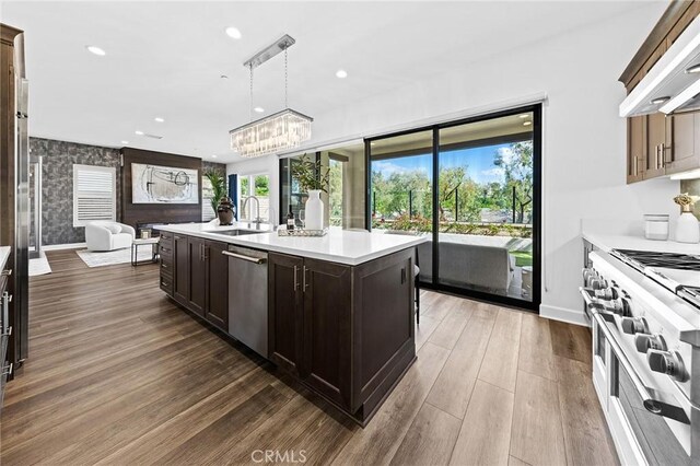 27 Alessio, Lake Forest, CA 92630 - kitchen featuring dishwasher, wall chimney range hood, open floor plan, plenty of natural light, and wallpapered walls