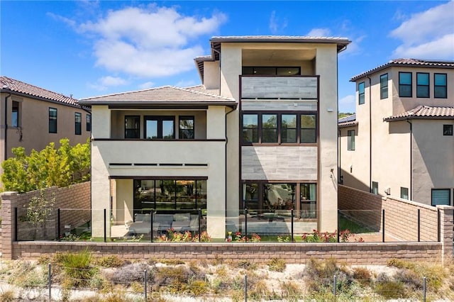 27 Alessio, Lake Forest, CA 92630 - rear view of property featuring a balcony, stucco siding, a fenced backyard, a tile roof, and a patio area