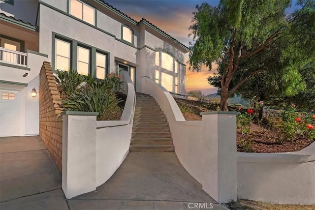 975 Manor Way, Corona, CA 92882 - property exterior at dusk featuring stairs and stucco siding