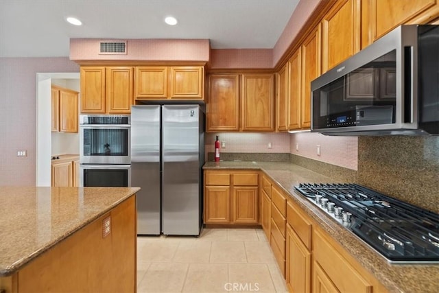 975 Manor Way, Corona, CA 92882 - kitchen featuring appliances with stainless steel finishes, light tile patterned floors, light stone countertops, tasteful backsplash, and recessed lighting