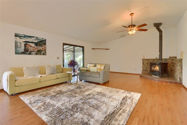 44800 Ahwahnee Acres Rd, Ahwahnee, CA 93601 - living area featuring light wood-type flooring, a wood stove, a ceiling fan, lofted ceiling, and baseboards