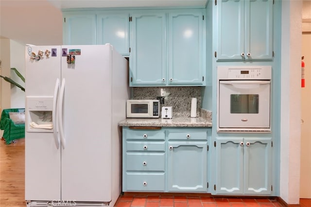 44800 Ahwahnee Acres Rd, Ahwahnee, CA 93601 - kitchen with white appliances, blue cabinets, backsplash, and light stone countertops