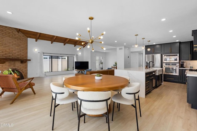 3960 W Hemlock St, Oxnard, CA 93035 - dining space with light wood-style floors, a chandelier, a brick fireplace, and recessed lighting