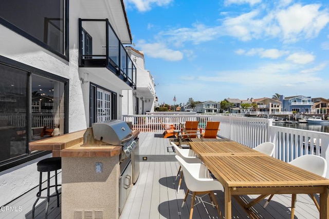 3960 W Hemlock St, Oxnard, CA 93035 - wooden terrace featuring outdoor dining space, a water view, exterior kitchen, a residential view, and a grill