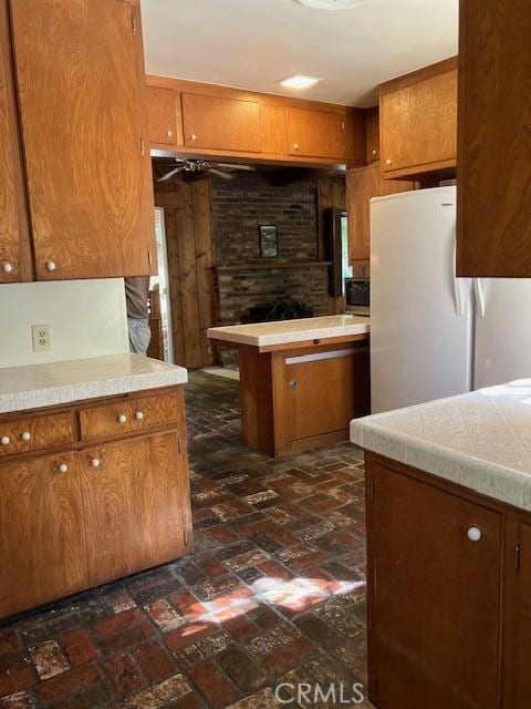 9656 Green Verdugo Dr, Shadow Hills, CA 91040 - kitchen featuring brick flooring, brown cabinets, light countertops, and freestanding refrigerator