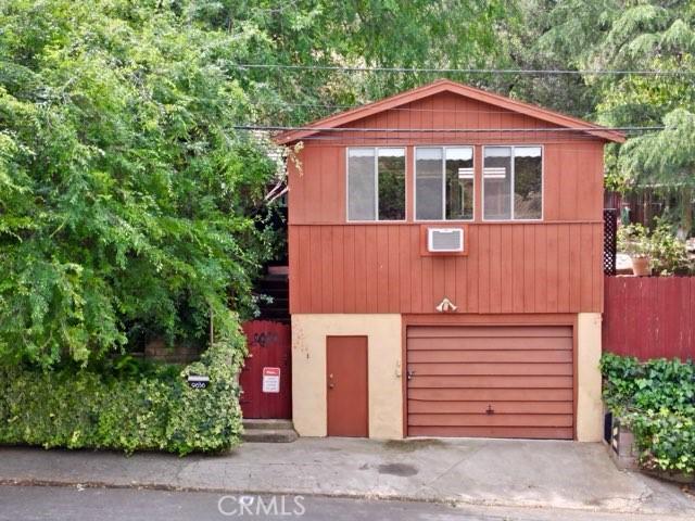 9656 Green Verdugo Dr, Shadow Hills, CA 91040 - rustic home featuring a garage, concrete driveway, and a wall mounted air conditioner