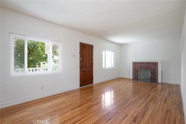 827 S Leland St, San Pedro, CA 90731 - unfurnished living room featuring light wood-type flooring, a fireplace, and baseboards