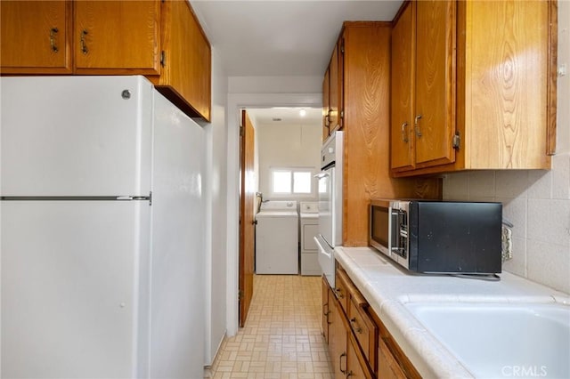 827 S Leland St, San Pedro, CA 90731 - kitchen featuring freestanding refrigerator, washer and clothes dryer, stainless steel microwave, brown cabinetry, and tile countertops