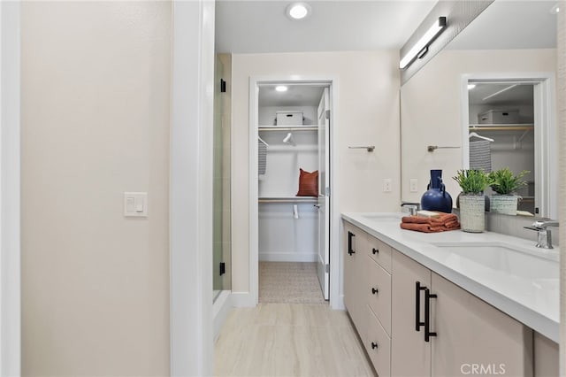 19041 Main St Unit 109, Huntington Beach, CA 92648 - bathroom with a spacious closet, a stall shower, baseboards, and double vanity