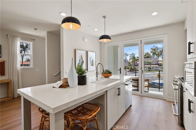 19041 Main St Unit 109, Huntington Beach, CA 92648 - kitchen featuring a sink, appliances with stainless steel finishes, white cabinetry, light wood-type flooring, and recessed lighting