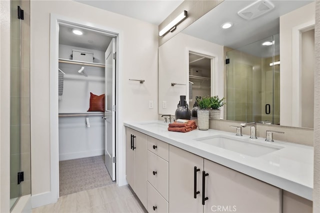 19041 Main St Unit 109, Huntington Beach, CA 92648 - full bath featuring a shower stall, a walk in closet, double vanity, baseboards, and recessed lighting