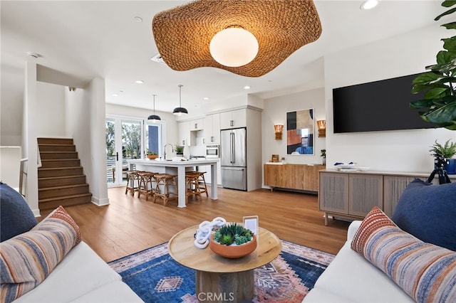 19041 Main St Unit 109, Huntington Beach, CA 92648 - living area with light wood finished floors, stairs, and recessed lighting
