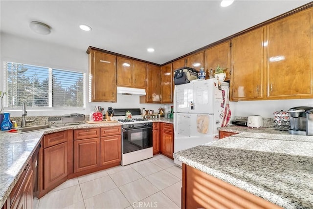 32490 Scandia Dr, Running Springs, CA 92382 - kitchen featuring gas range, freestanding refrigerator, a sink, under cabinet range hood, and brown cabinetry