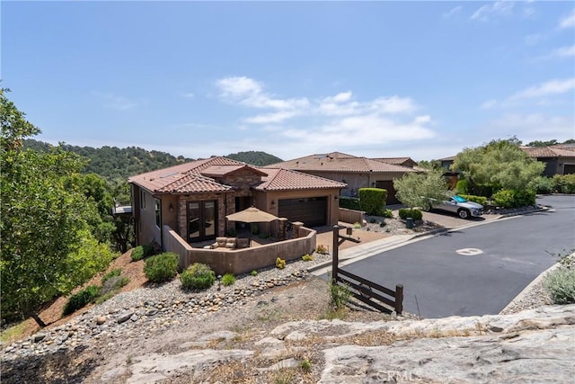 2815 Rock Wren Ln, Avila Beach, CA 93424 - view of front of house featuring an attached garage, a tiled roof, and stucco siding