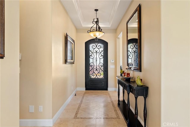 2815 Rock Wren Ln, Avila Beach, CA 93424 - entryway with crown molding, baseboards, a tray ceiling, arched walkways, and inlaid floor details