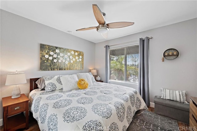 bedroom featuring wood finished floors, baseboards, and ceiling fan