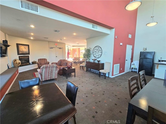 2742 Cabrillo Ave Unit 201, Torrance, CA 90501 - dining space with carpet floors, a glass covered fireplace, baseboards, a towering ceiling, and recessed lighting